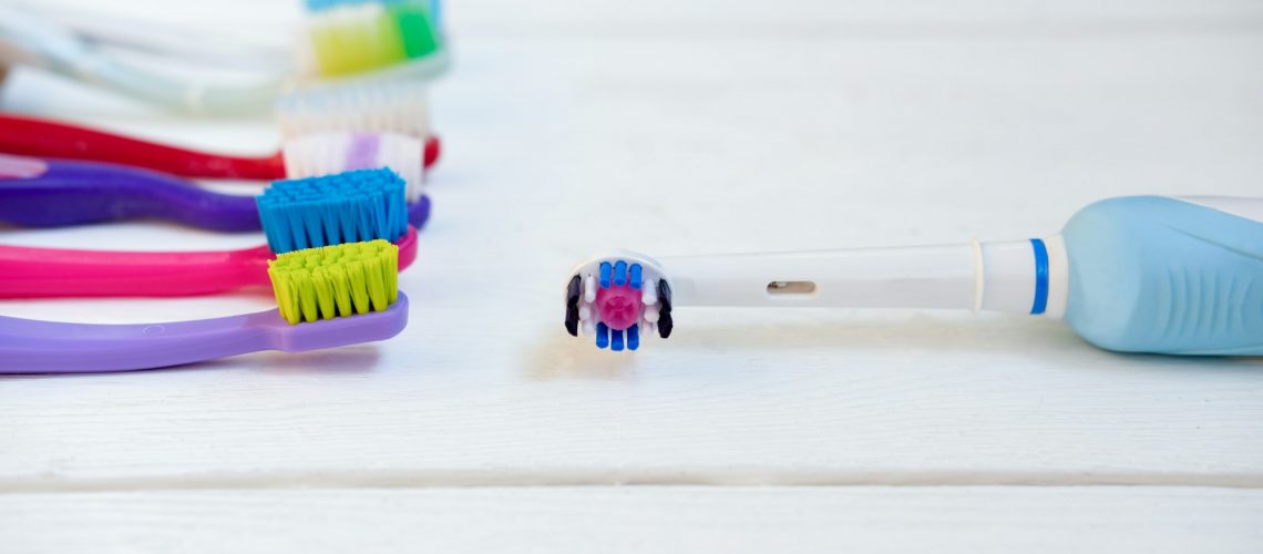 Comparison of electric toothbrush and manual toothbrushes to illustrate choosing the right dental care tools, for Wells Family Dental's guide on selecting appropriate toothpaste and toothbrush